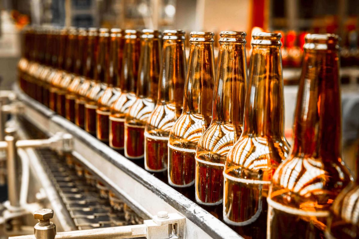 Birra artigianale in bottiglia su nastro trasportatore