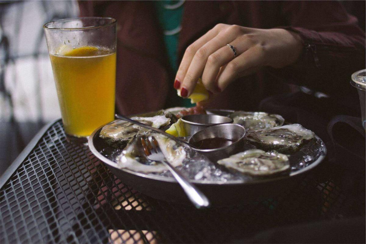 Una foto del tipico piatto di ostriche accompagnato da un boccale di birra