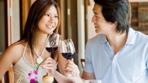 Vino italiano in Cina: due giovani sorseggiano un calice giovani cinesi bevono vino italiano